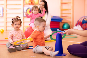 Nursery babies group doing sport in gym