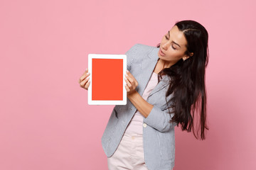 Portrait of young woman in striped jacket hold, looking on tablet pc computer with blank empty screen isolated on pink pastel background. People sincere emotions lifestyle concept. Mock up copy space.