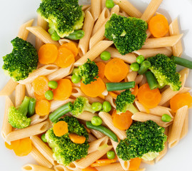 Whole wheat pasta Penne with broccoli, carrots, green peas. Close-up, macro. Diet menu, proper nutrition, healthy food