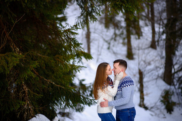 outdoor fashion portrait of young sensual couple in cold winter wather. love and kiss