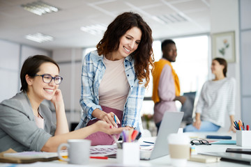 Portrait oft wo contemporary women enjoying work in office collaborating on creative project, copy space