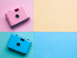 Pastel film camera on color paper background 
