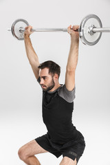 Naklejka premium Young sports fitness man isolate over white wall background make exercises with barbell.