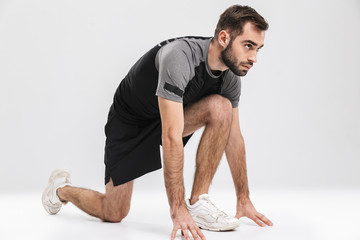 Obraz premium Handsome young sports fitness man runner posing isolate over white wall background.
