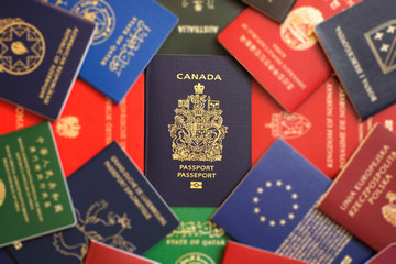 Canada's blue biometric passport among the blurry multicolored passports of many countries of the world