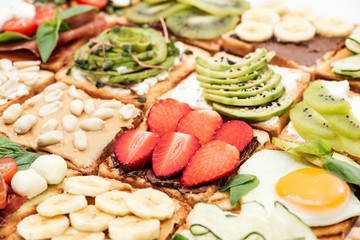 Toasts with cut fruits, strawberry. fried egg and peanuts