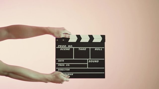 Close up of hands using black film clapper board. Male hands holds and claps movie production slate