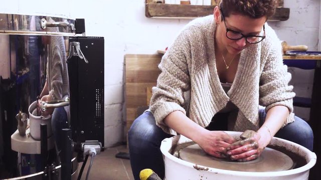 Woman working on a potter's wheel. Pottery