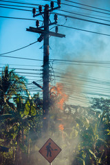 power pylon overload or electric short circuit at transformer on poles and fire or flame with smoke...