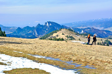 Obraz premium Two young tourist women looking at amazing mountains in early spring, travel concept, Pieniny mountains, Szczawnica, Poland