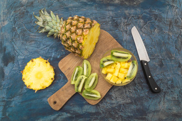 Delicious and healthy kiwi and pineapple fruit on old rustic desk