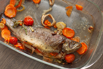  Cooked sea fish dorado in a glass saucepan with lemon and spices and vegetables. Homemade recipe cooking concept. Flat top view from above.
