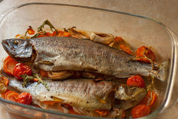  Cooked sea fish dorado in a glass saucepan with lemon and spices and vegetables. Homemade recipe cooking concept. Flat top view from above.