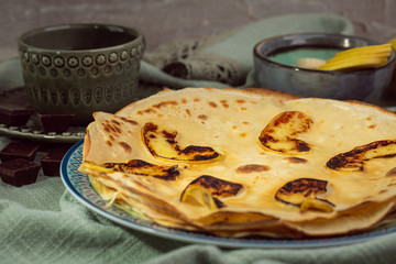 Cooked crepes folded on a plate with jam and apples