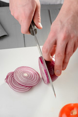 Man slicing a red onion
