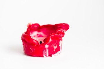 Melted red candle on white background