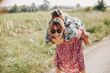 Fashionable mother with daughter. Family in a summer fiels. Girl in a red dress.