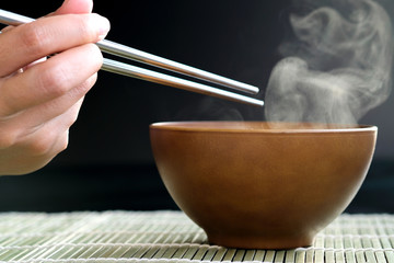 Decorate food, Japanese Food , Breakfast , Lunch and dining by hot soup in wood bowl on mat which have a smoke on bowl black background.