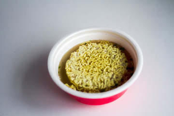Instant noodles in red plate on white background