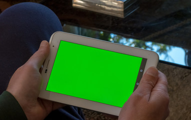 Man using a tablet with green screen