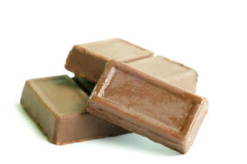 Chocolates are cut into pieces on a white background. Snack ideas