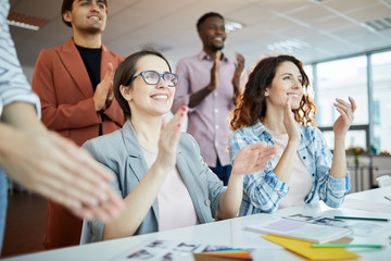 Portrait of multi-ethnic business team clapping during   presentation in office, copy space