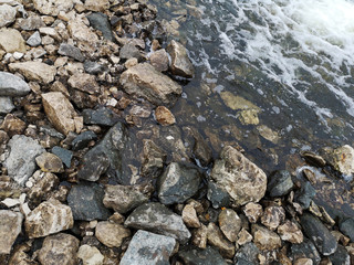 Fresh water stream in mountain brook, closeup. The texture of the rocky surface in the water