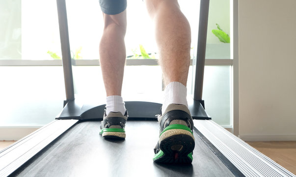 leg of man running on treadmill in the gym which runner athletic by running shoes. Health and sport concept background,