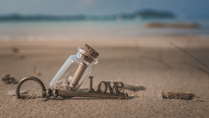 Message In Bottle And Vintage Key On Beach