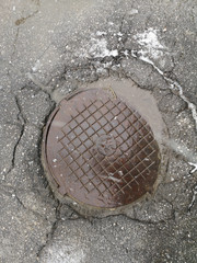 The manhole cover in the asphalt road closeup to use as background