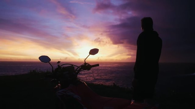 Back view of mam silhouette with motorbike