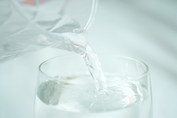 Clean water for good health. Pouring Fresh Pure Water From Pitcher Into A Glass on table wooden. Health And Diet Concept. Lifestyle Healthcare And Beauty.