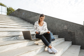 Cheerful young teenage girl sitting on a staircase