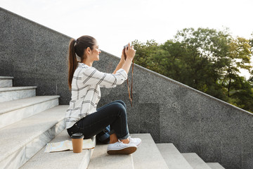 Cheerful young teenage girl sitting on a staircase