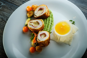 top view closeup dissected chicken Kiev cutlets with grilled vegetables
