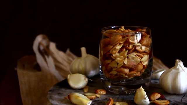 Tilting down video shot of toasted peanuts and garlic chips