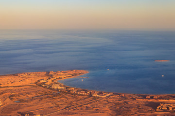 Aerial view on Red sea, Arabian desert and touristic resort near Hurghada, Egypt. View from airplane