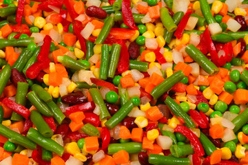 Sliced vegetables, corn, beans, peas, carrots, sweet peppers background.