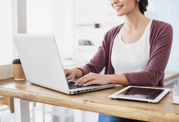 Woman using laptop at home. Young beautiful girl working on computer. Entrepreneur, businesswoman, freelance worker, student typing on keyboard