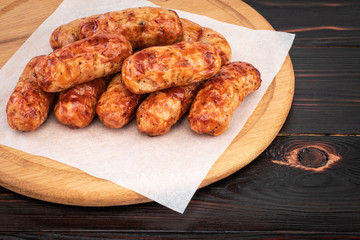 Tasty grilled sausage on the wooden background