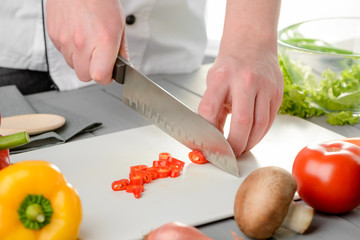 Chef slicing a red pepper