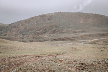 a scene of beautiful and majestic mountainous mountains against the background of a cloudy sky with...