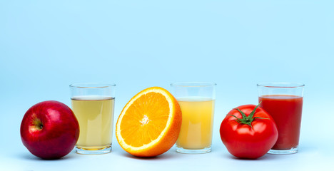 Fresh orange, apple, tomato juices on a blue background. Healthy and natural drinks. Diet and...