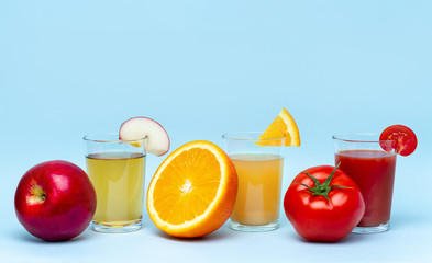 Fresh orange, apple, tomato juices on a blue background. Healthy and natural drinks. Diet and...