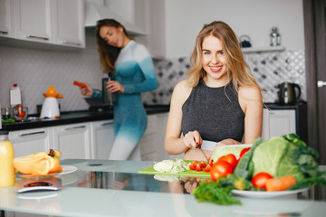 Two sports girls. Woman with vegetables. Lady in a sport clothes