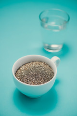 Glass of water and healthy chia seeds in a spoon. Text space.