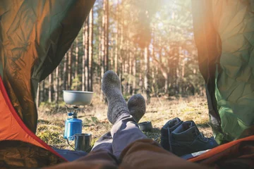 Selbstklebende Fototapeten wanderlust outdoor camping - traveler feet out of the tent © ronstik