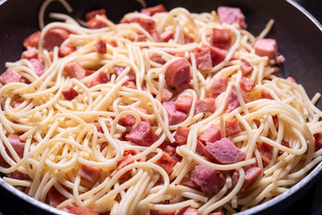 spaghetti with sausage in a frying pan