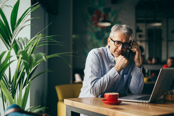 man using cellphone in cafeteria
