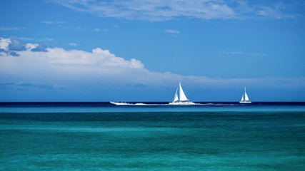 Pastoral landscape of the sea surface with small sailboats and boats in the Dominican Republic